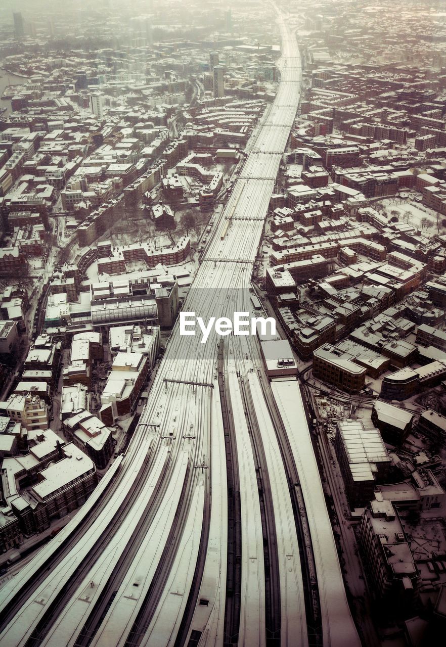 HIGH ANGLE VIEW OF RAILROAD TRACKS BY CITY