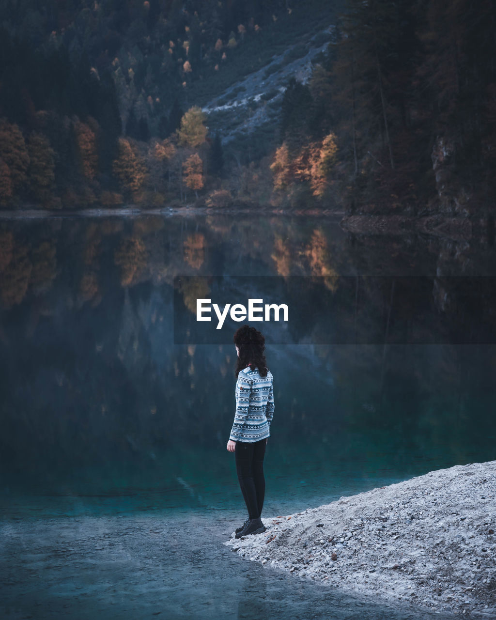 Full length of woman standing by lake