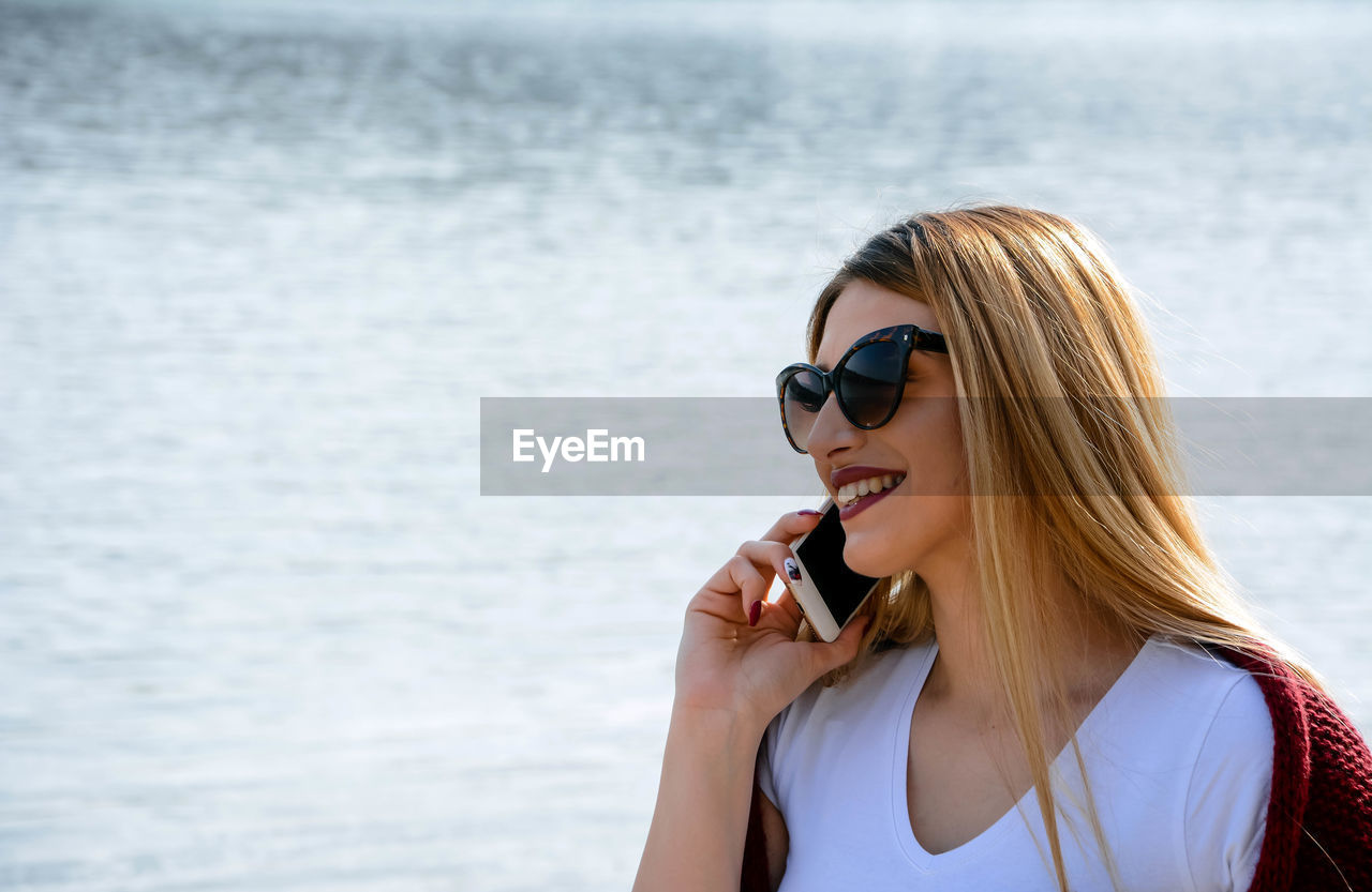 Portrait of young woman wearing sunglasses at beach