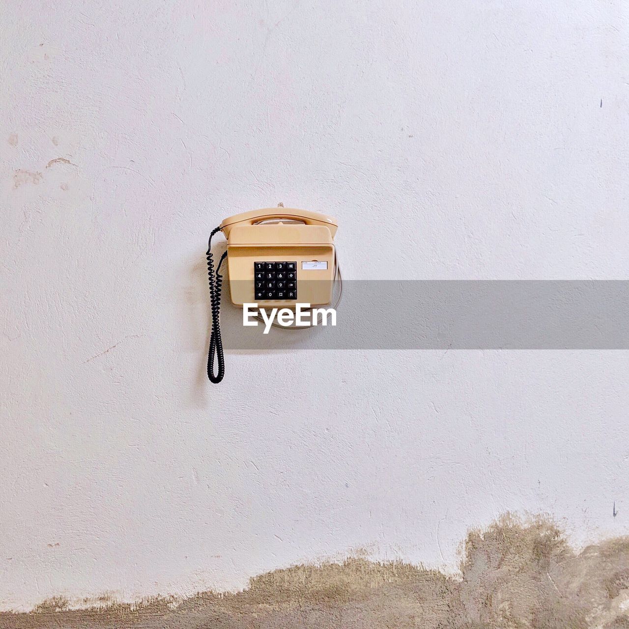 Landline phone hanging on white wall