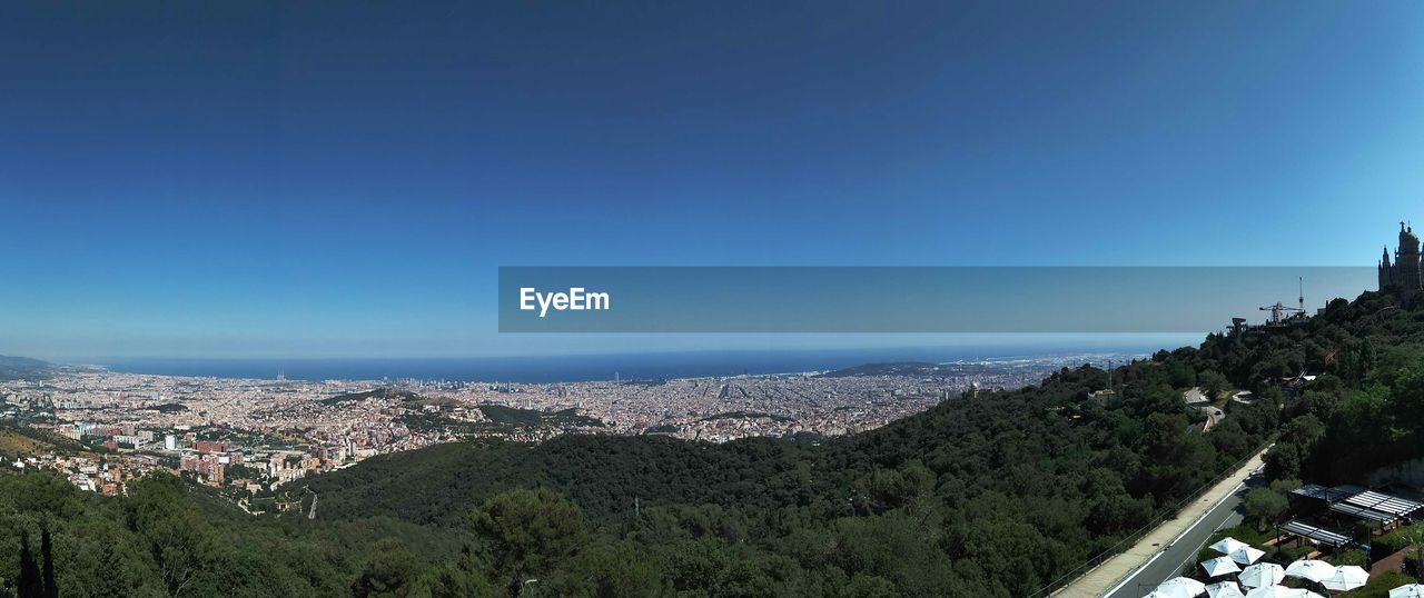 HIGH ANGLE VIEW OF TOWN AGAINST CLEAR BLUE SKY