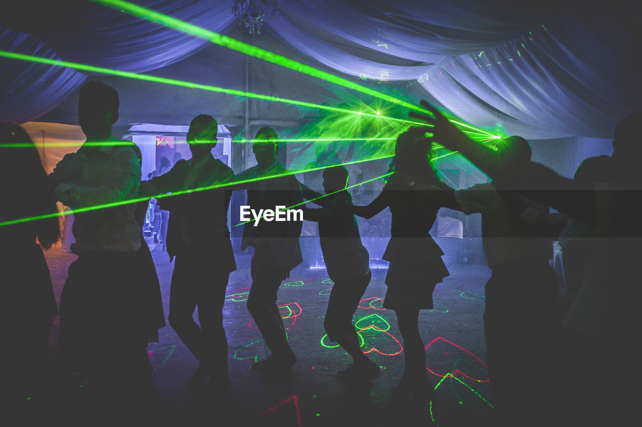 Group of people dancing in nightclub during party