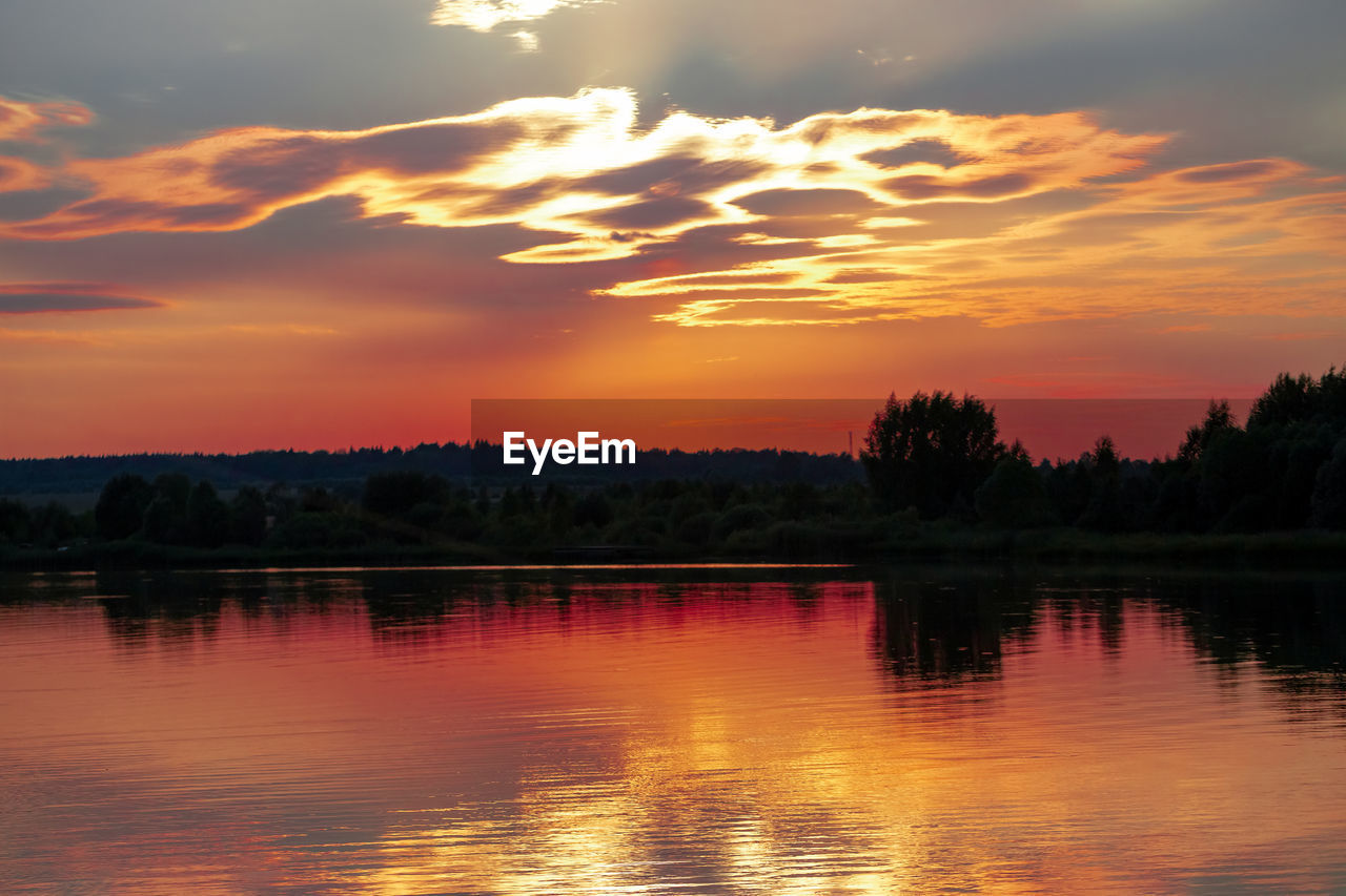 SCENIC VIEW OF LAKE AGAINST ORANGE SKY