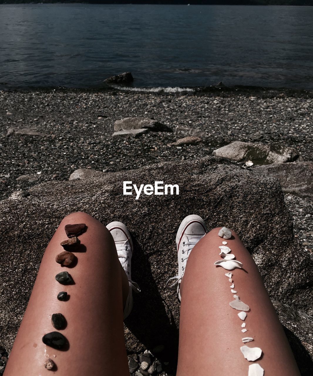 Low section of woman sitting on beach