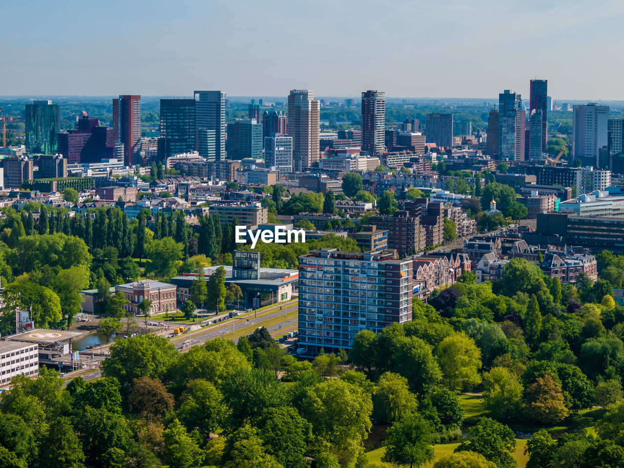 Aerial cityscape of a part of the city of rotterdam, buildings, skyscraper abundant green trees