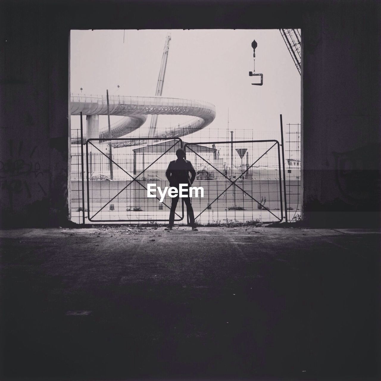 Full length of man standing at main gate of construction site