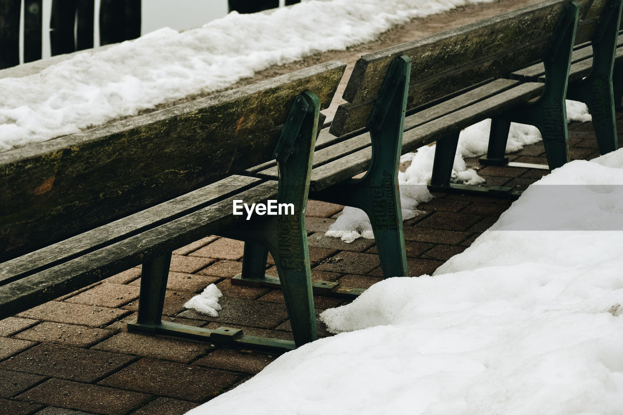 VIEW OF WOODEN BENCH ON SNOW COVERED TABLE
