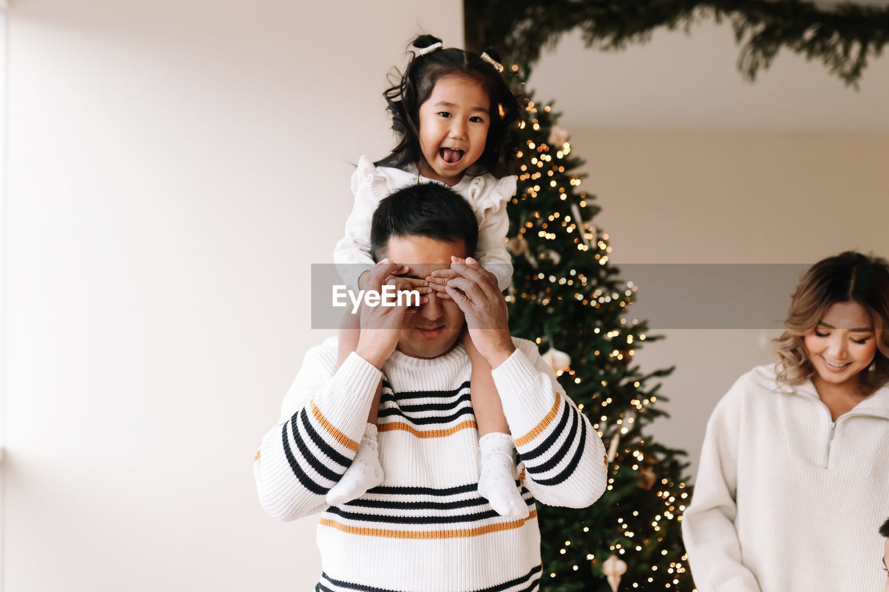 Asian multi-racial family with two children celebrate christmas holiday in decorated indoor house