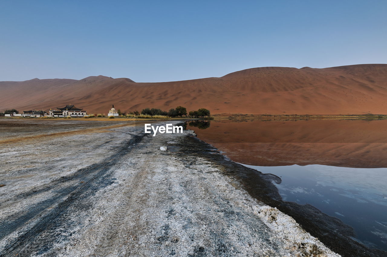 1123 sumu jaran lake and badain jaran desert temple-sand megadunes reflected on mirror water. china.