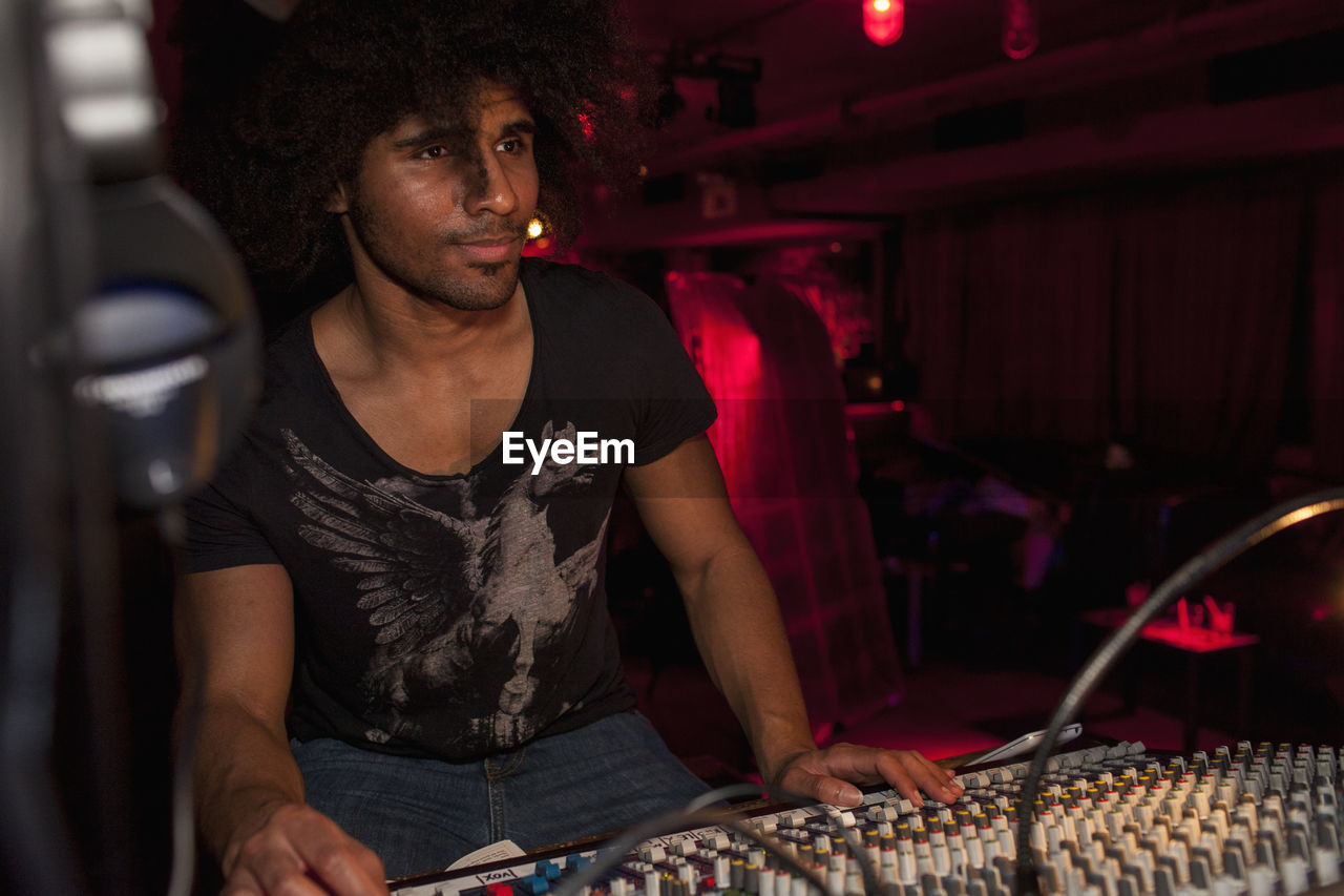 Young man djing at a night club