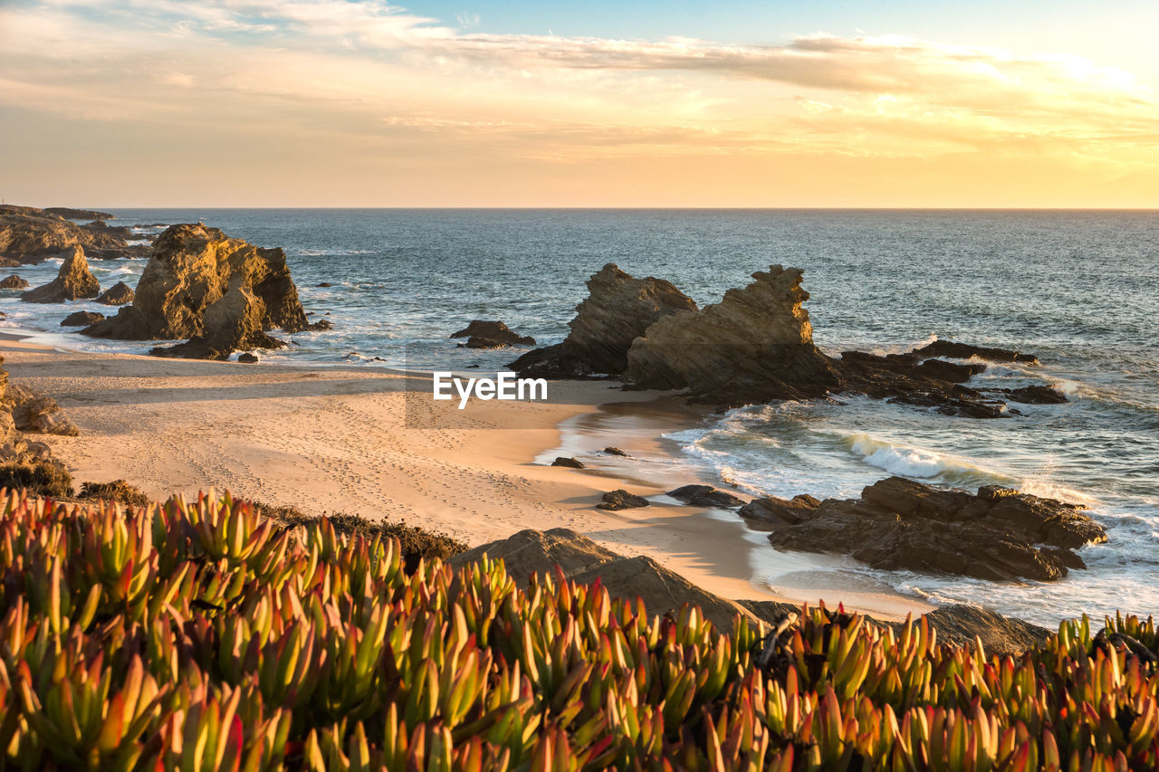 SCENIC VIEW OF ROCKS ON SEA AGAINST SKY