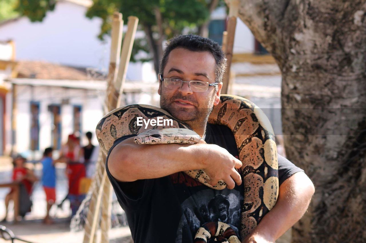 Man holding snake in city