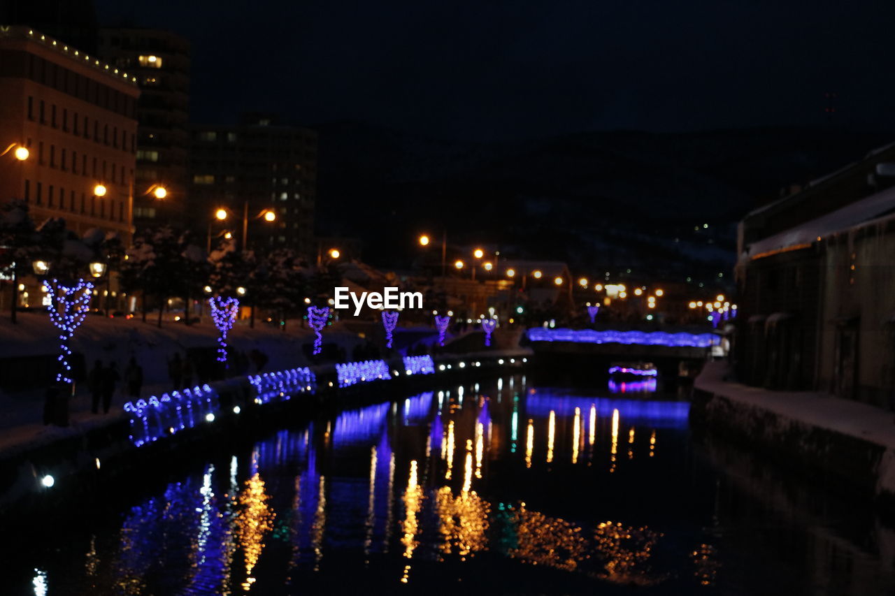 ILLUMINATED REFLECTION OF WATER IN SKY AT NIGHT