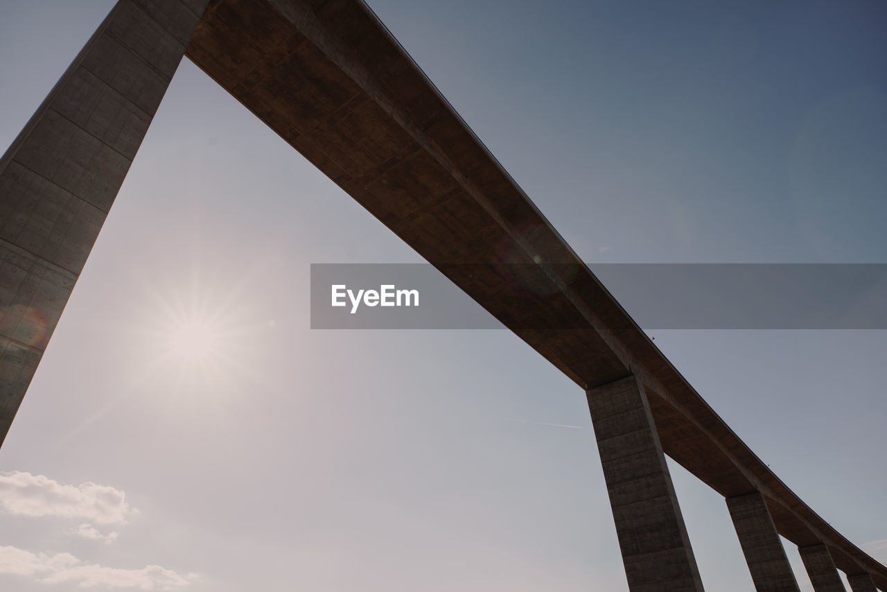 LOW ANGLE VIEW OF BRIDGE AGAINST SUN