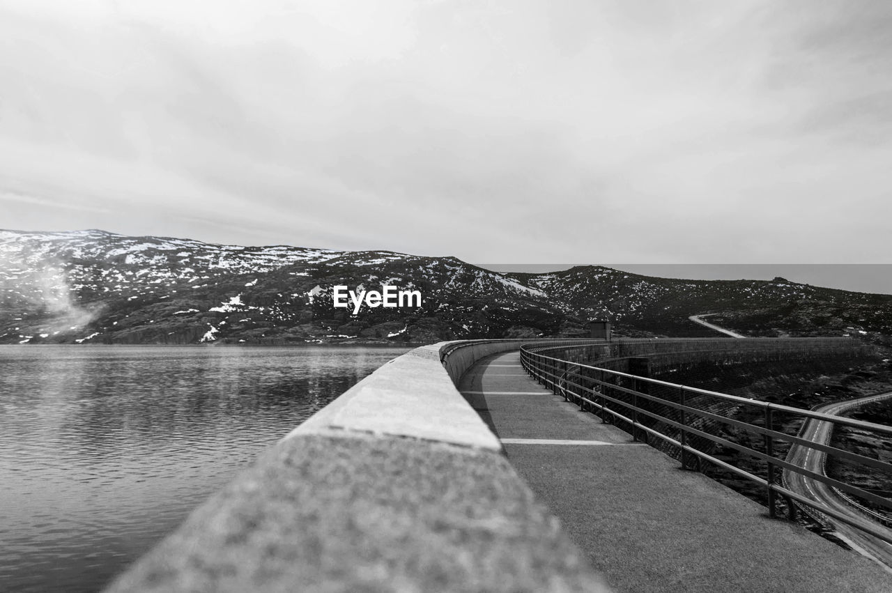 Scenic view of river by mountains against sky