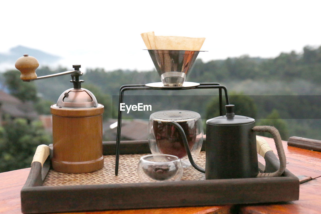 food and drink, drink, no people, household equipment, cup, nature, coffee pot, iron, kitchen utensil, mug, metal, food, wood, table, day, coffee, kettle, refreshment, hot drink, focus on foreground, teapot, tea, outdoors