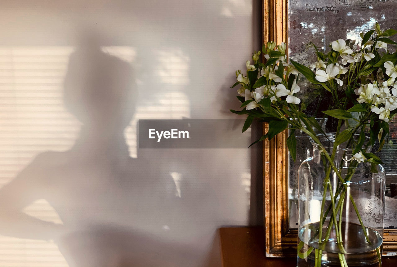 FLOWER VASE ON TABLE BY WINDOW