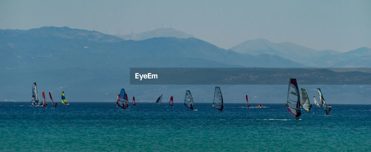 People windsurfing on sea