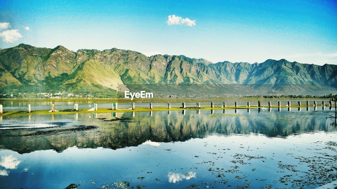 Scenic view of lake and mountains against blue sky