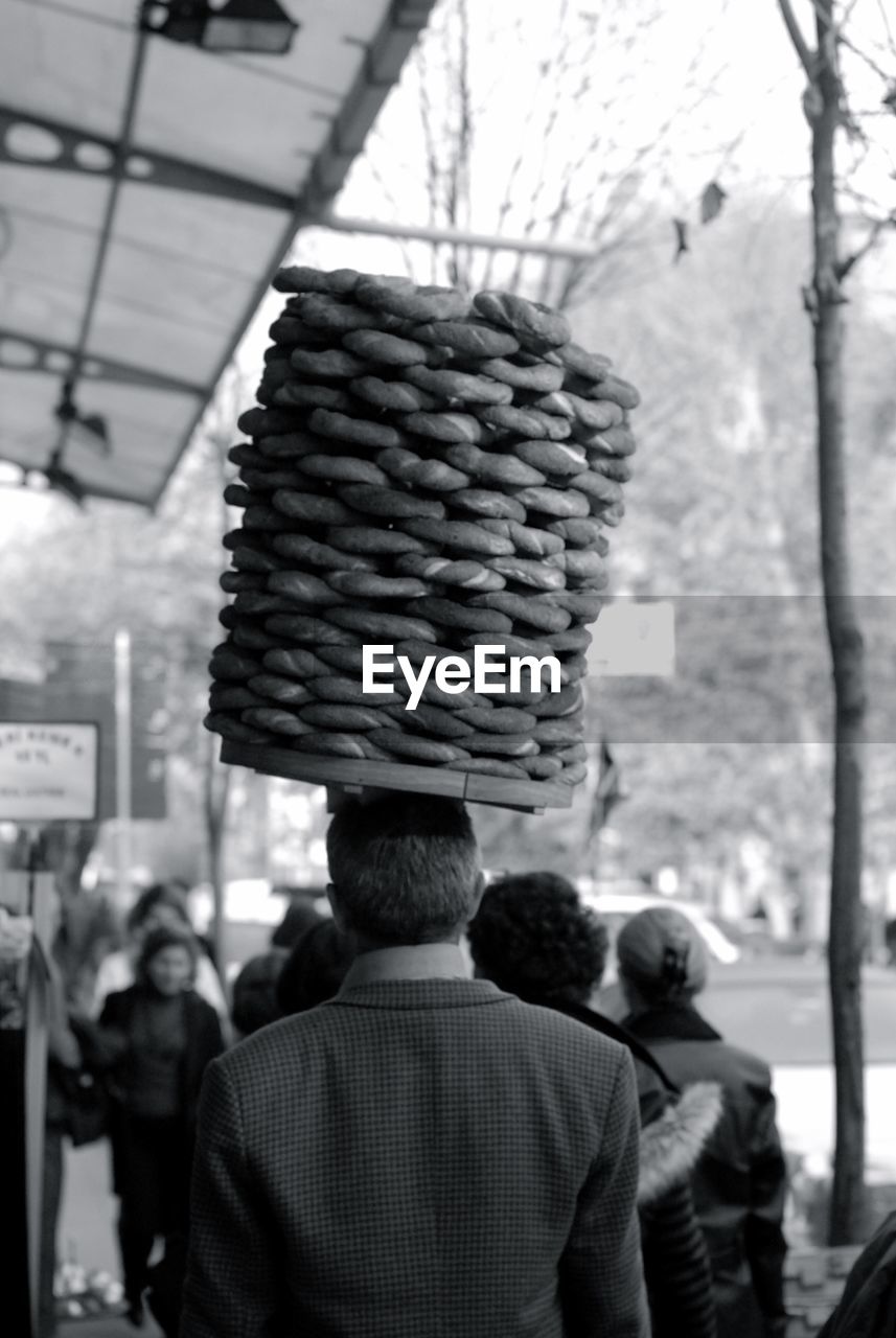 Rear view of man carrying buns on head