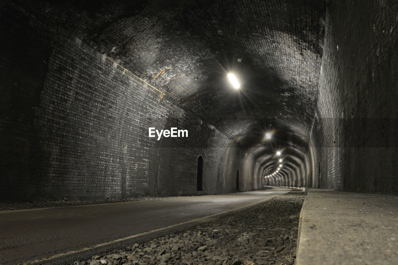 Monsal trail road passes through a tunnel with copy space. old and rustic tunnel.