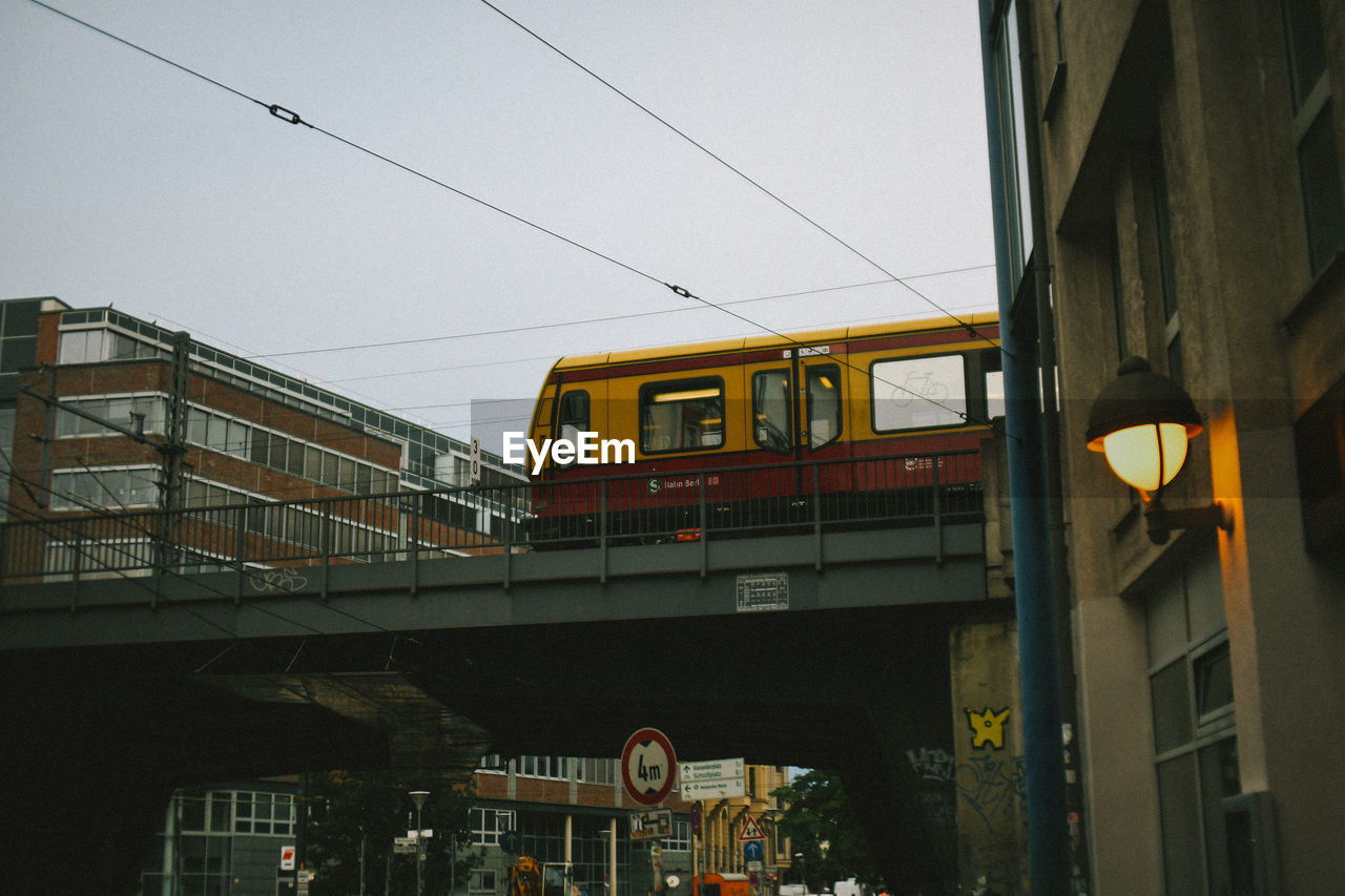 LOW ANGLE VIEW OF TRAIN IN CITY AGAINST SKY