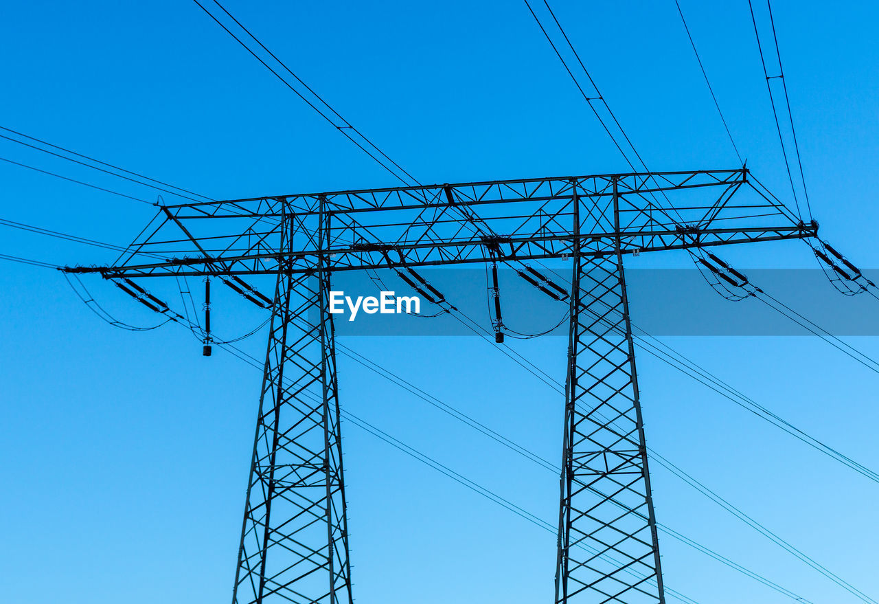 LOW ANGLE VIEW OF ELECTRICITY PYLON AGAINST CLEAR BLUE SKY