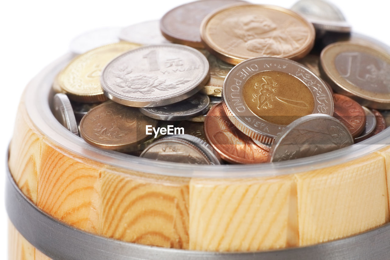 High angle view of coins in container against white background
