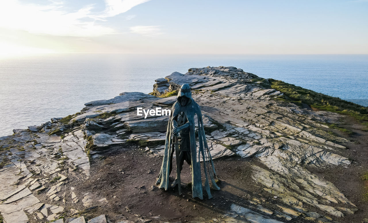 Monument to king arthur on a rock against the backdrop of the ocean