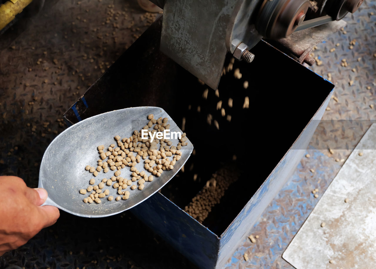 High angle view of person holding food in spoon by machine