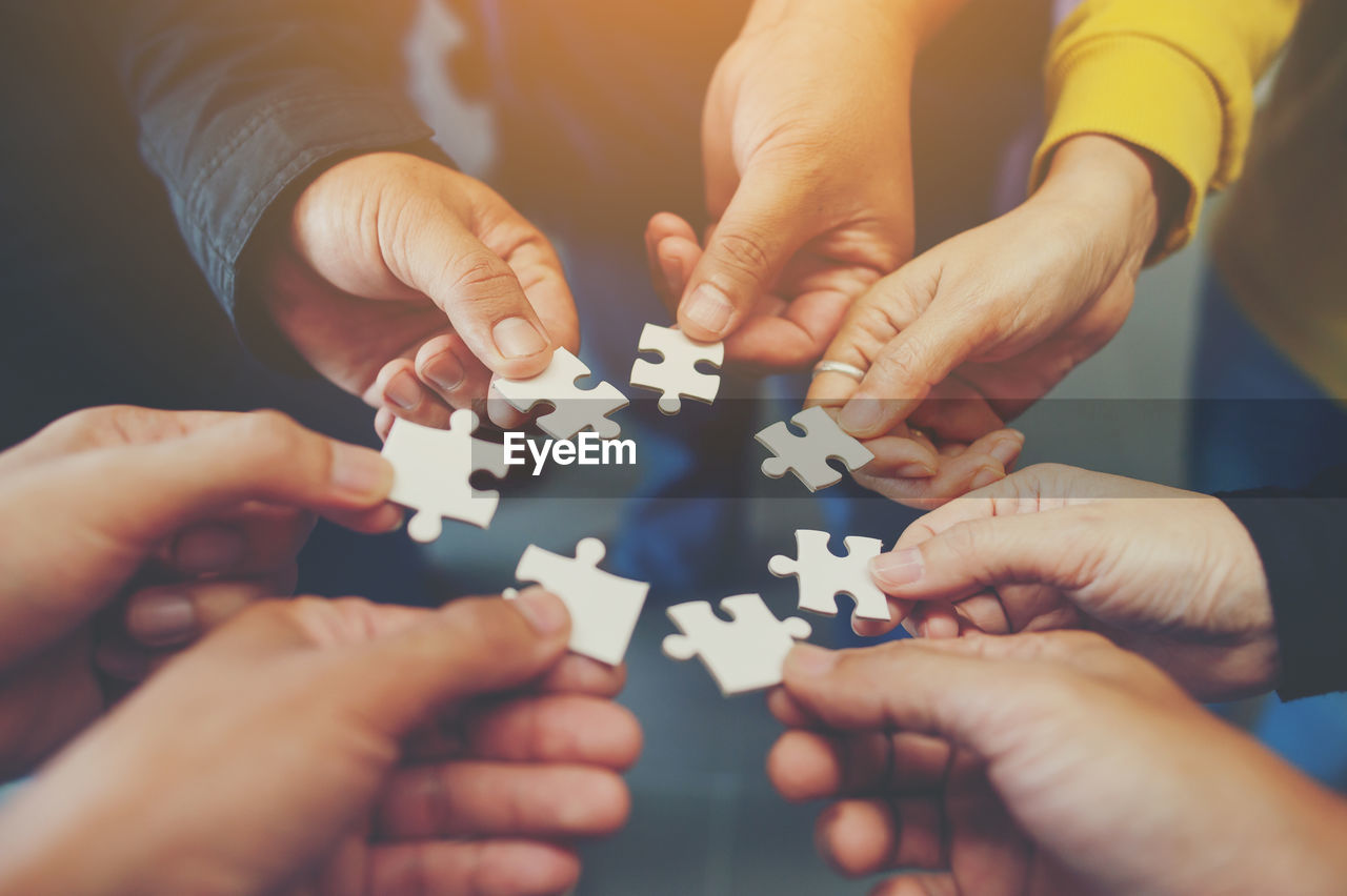 Cropped image of friends playing jigsaw puzzle