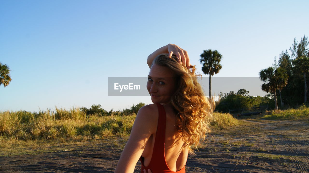 Woman in swimwear standing on land during sunny day