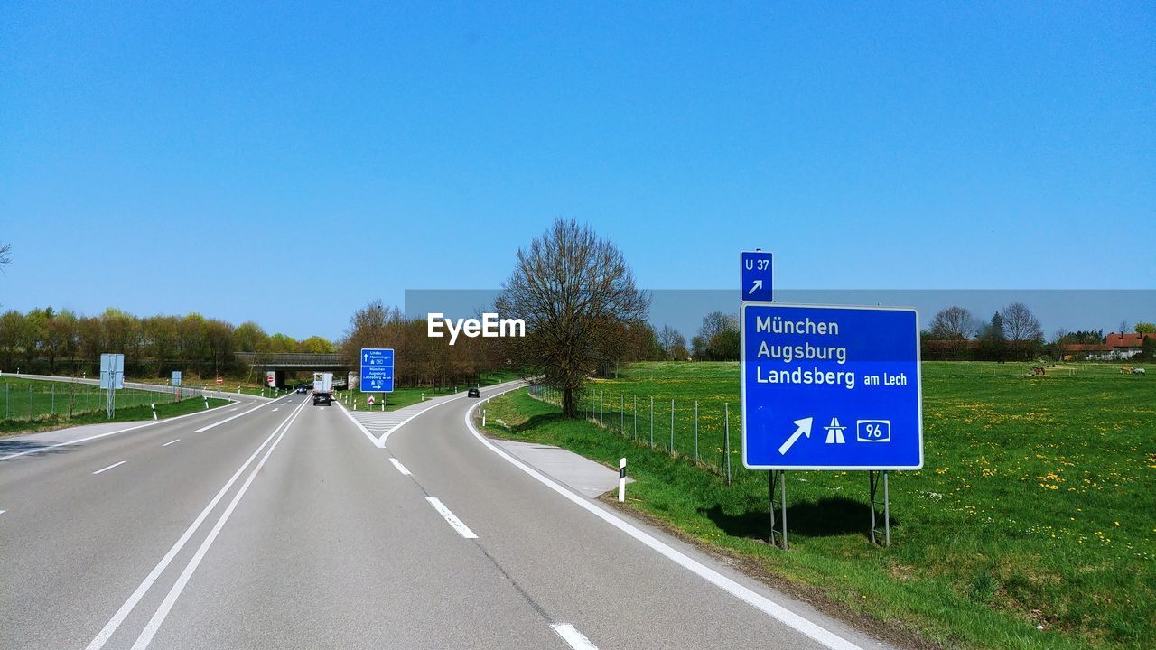 Road sign against clear blue sky