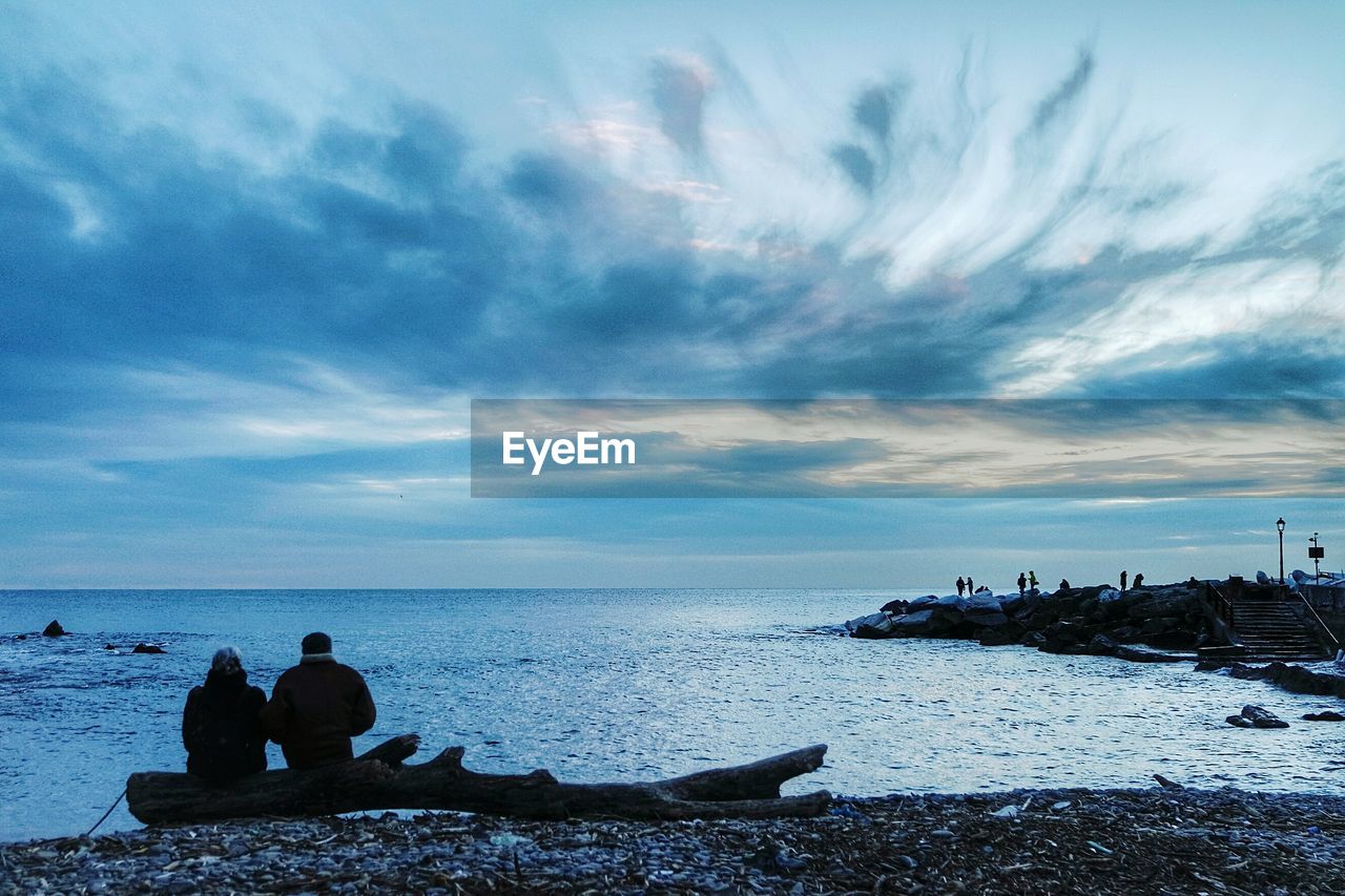 Rear view of couple overlooking calm sea