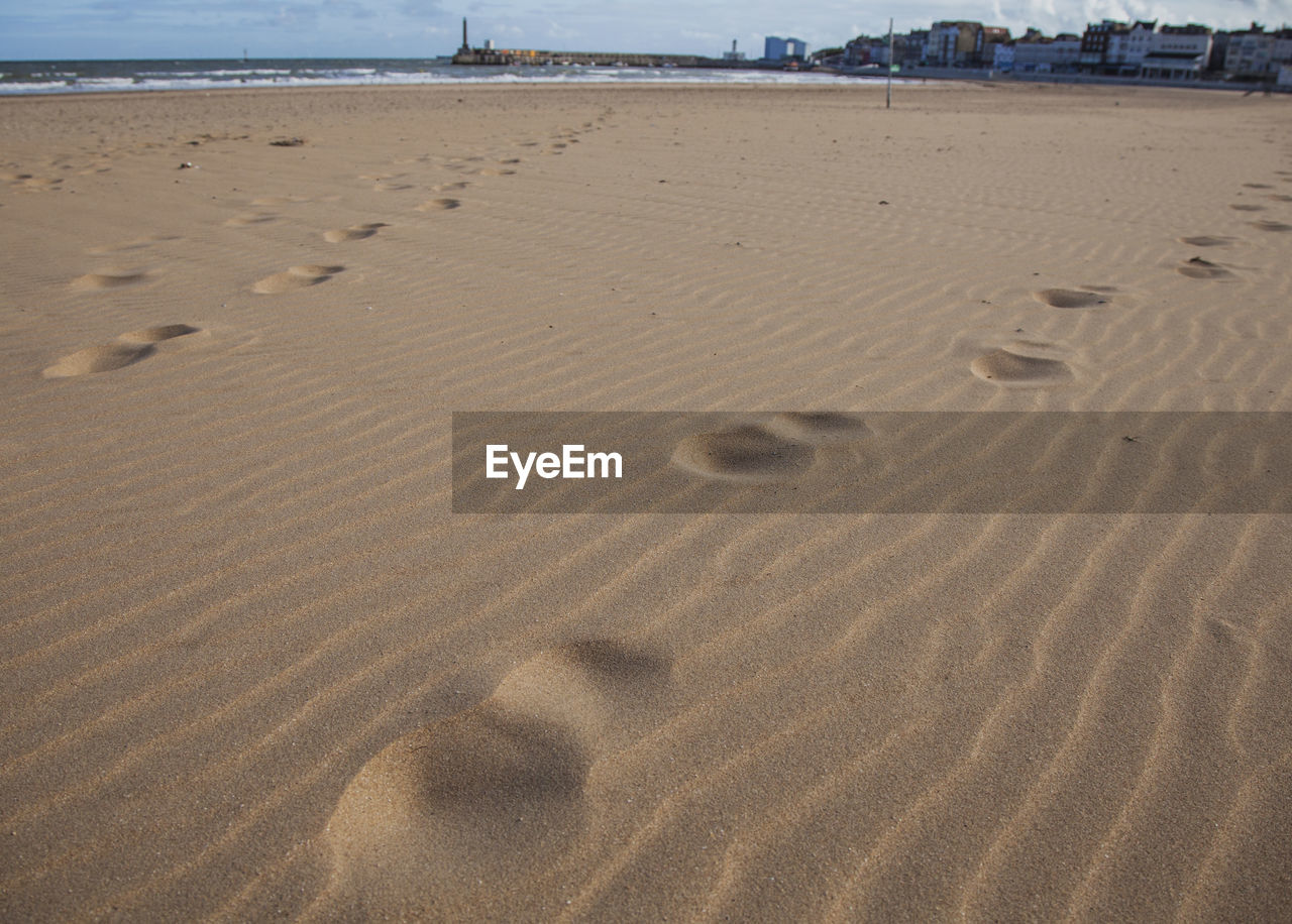 HIGH ANGLE VIEW OF FOOTPRINTS ON BEACH