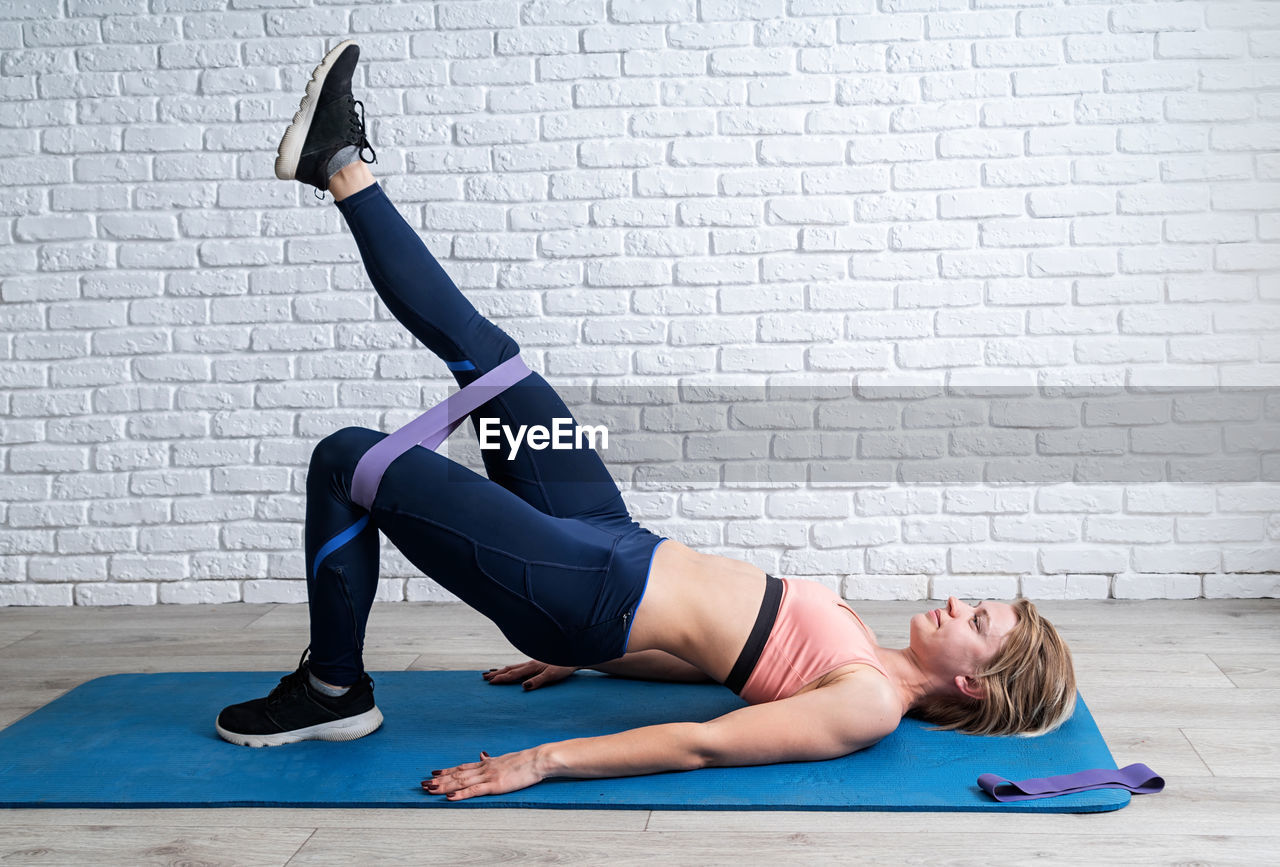 WOMAN WITH ARMS RAISED ON FLOOR