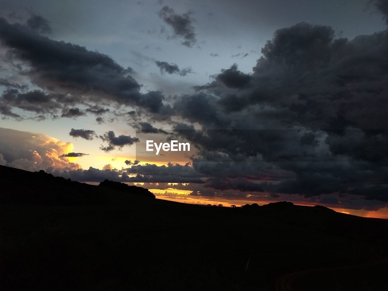 SCENIC VIEW OF SILHOUETTE MOUNTAIN AGAINST DRAMATIC SKY