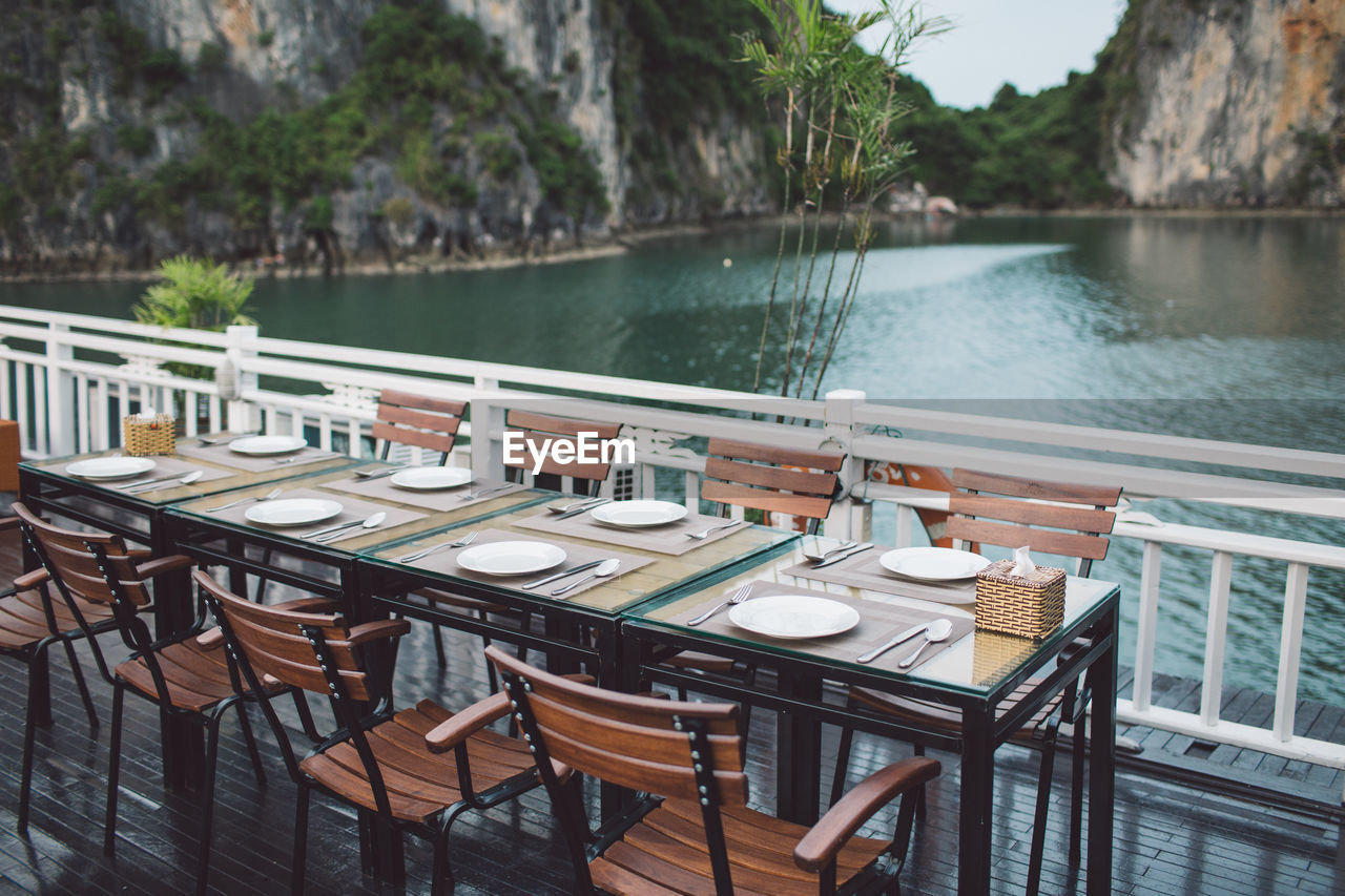 Place setting at restaurant against lake