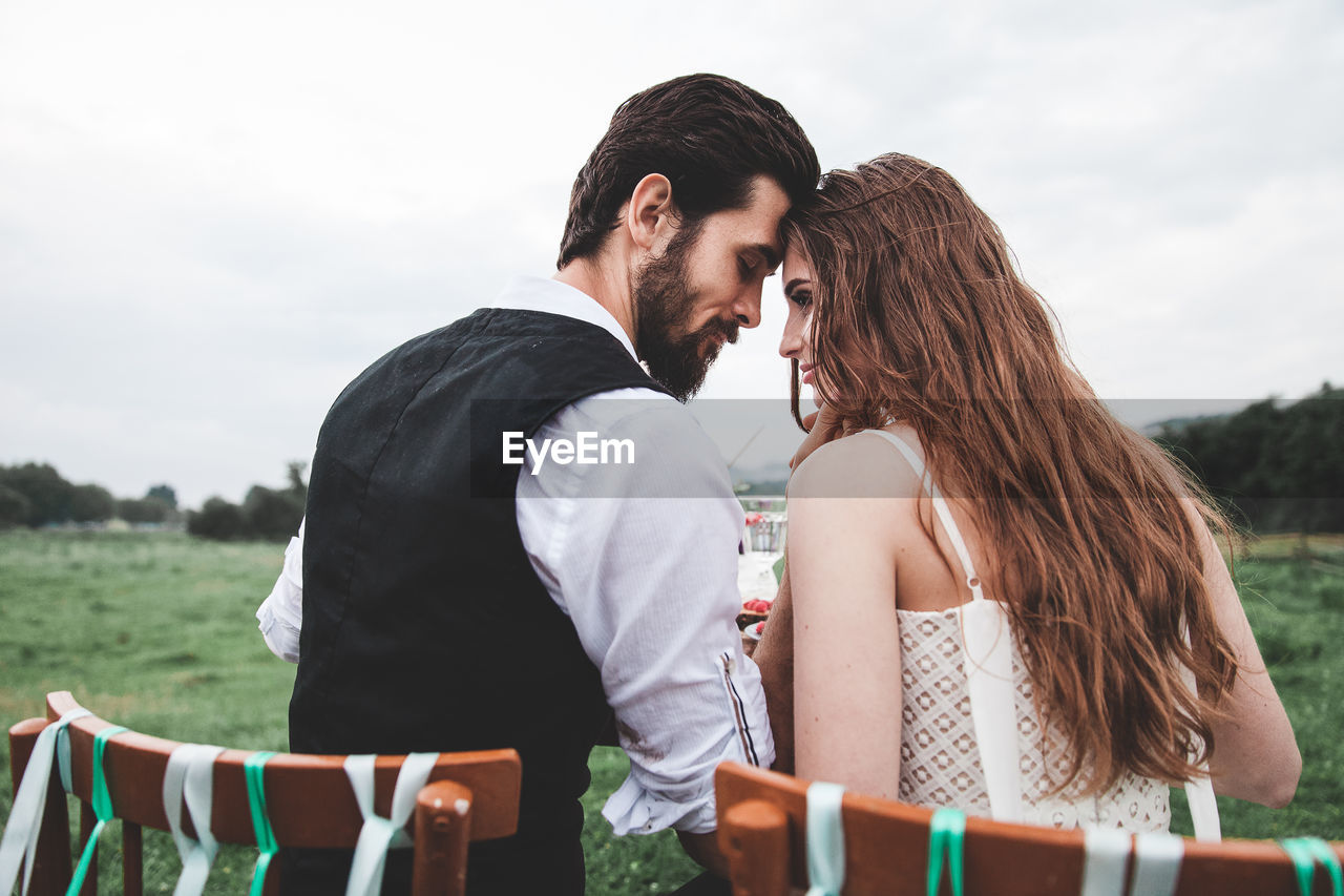 Rear view of wedding couple falling in love at farm