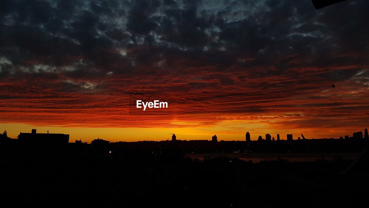 SILHOUETTE BUILDINGS AGAINST DRAMATIC SKY