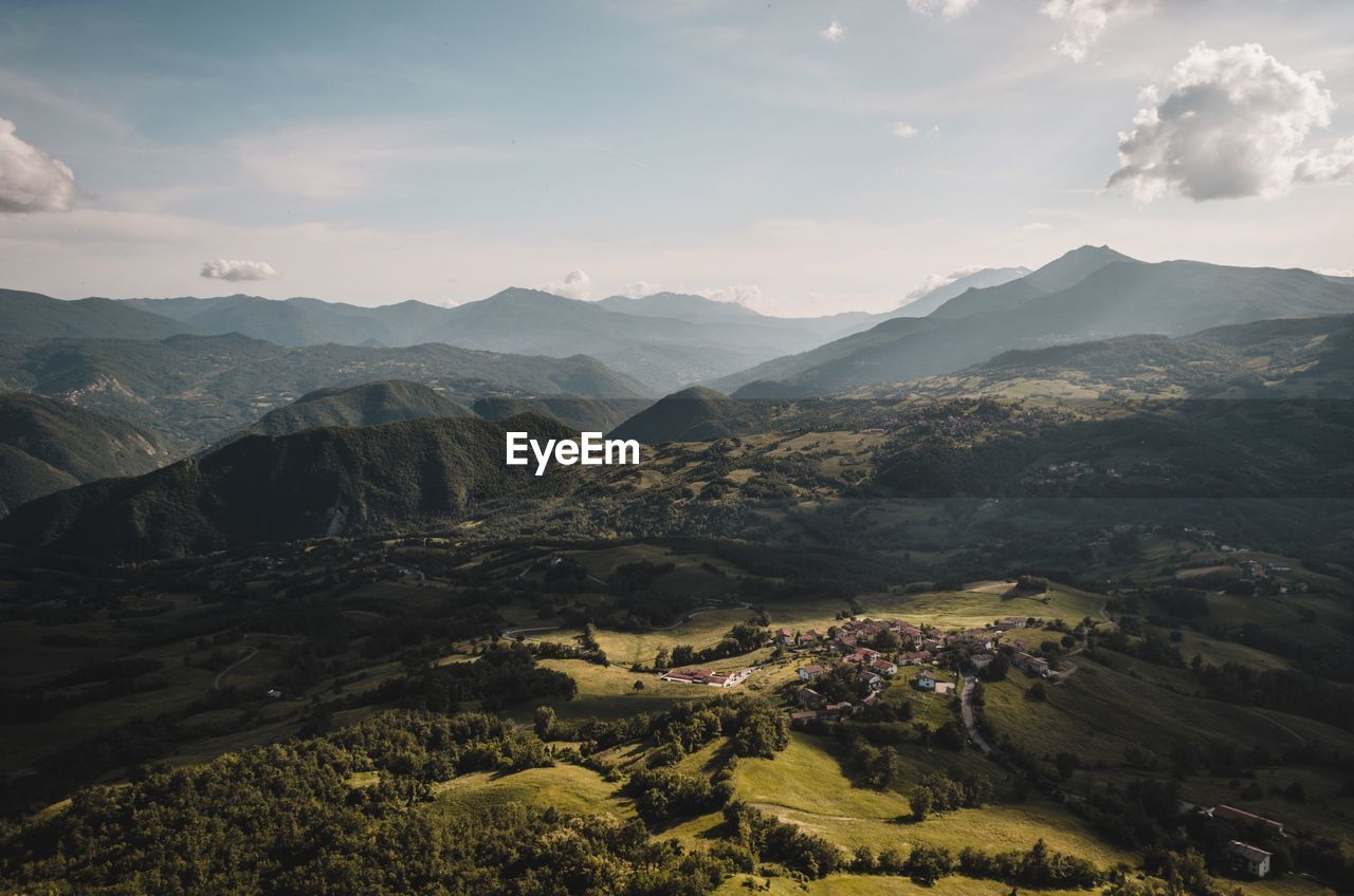 Scenic view of valley and mountains against sky