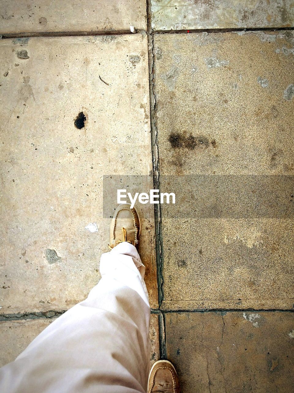 LOW SECTION OF MAN STANDING ON COBBLESTONE