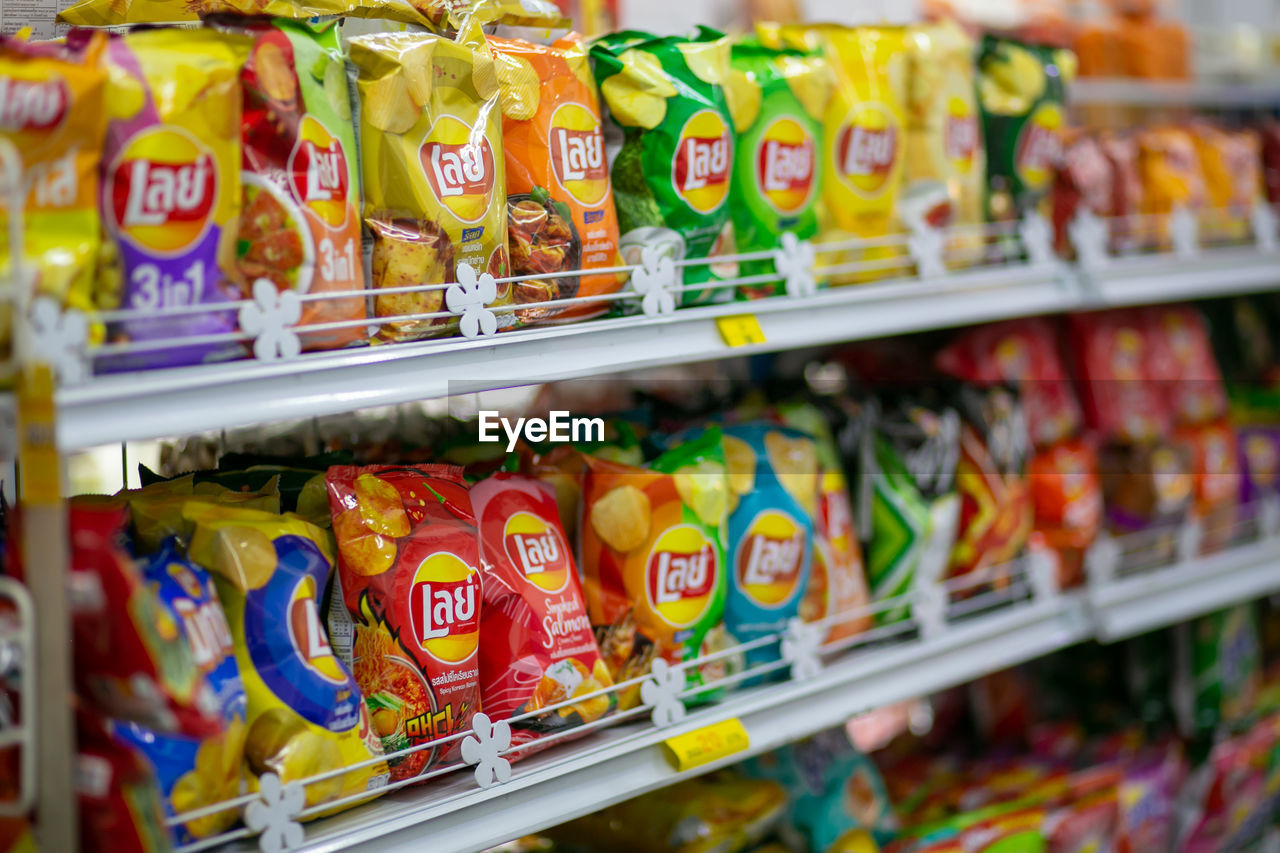 supermarket, convenience store, grocery store, retail, store, food, shelf, convenience food, food and drink, variation, large group of objects, market, shopping, multi colored, abundance, no people, in a row, selective focus, consumerism, indoors, business, order, arrangement, soft drink