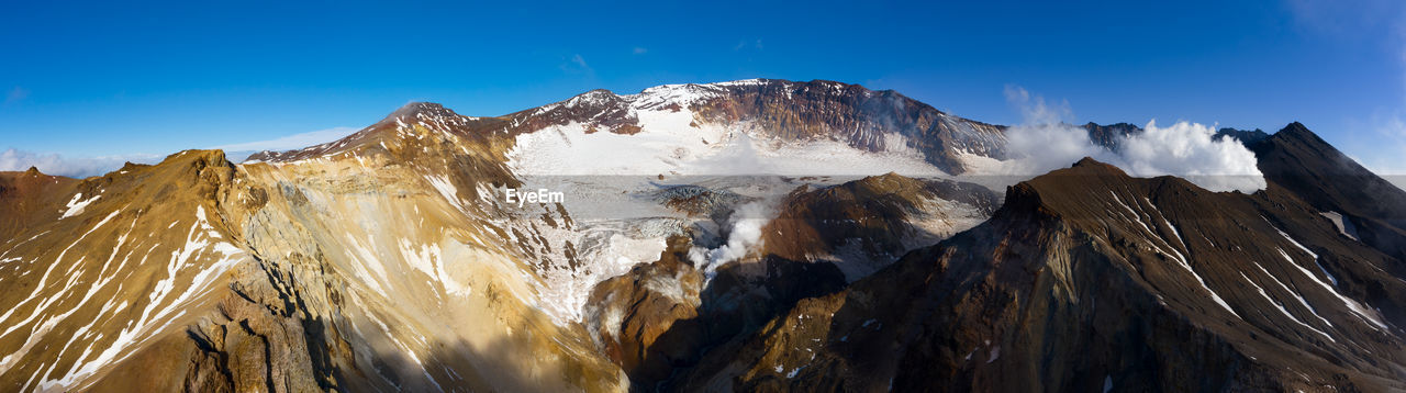 PANORAMIC VIEW OF SNOWCAPPED MOUNTAIN AGAINST BLUE SKY