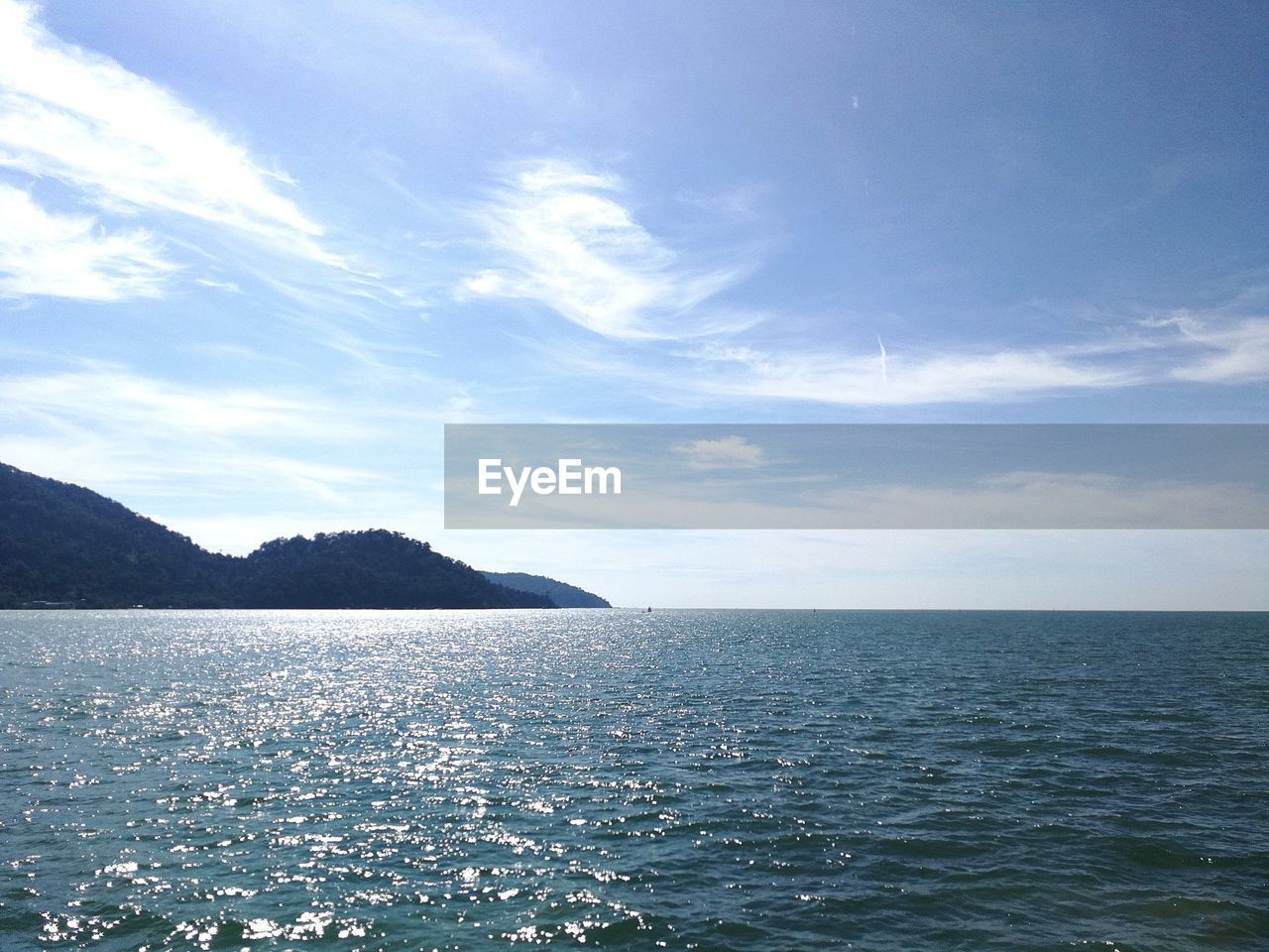 SCENIC VIEW OF SEA BY MOUNTAIN AGAINST SKY