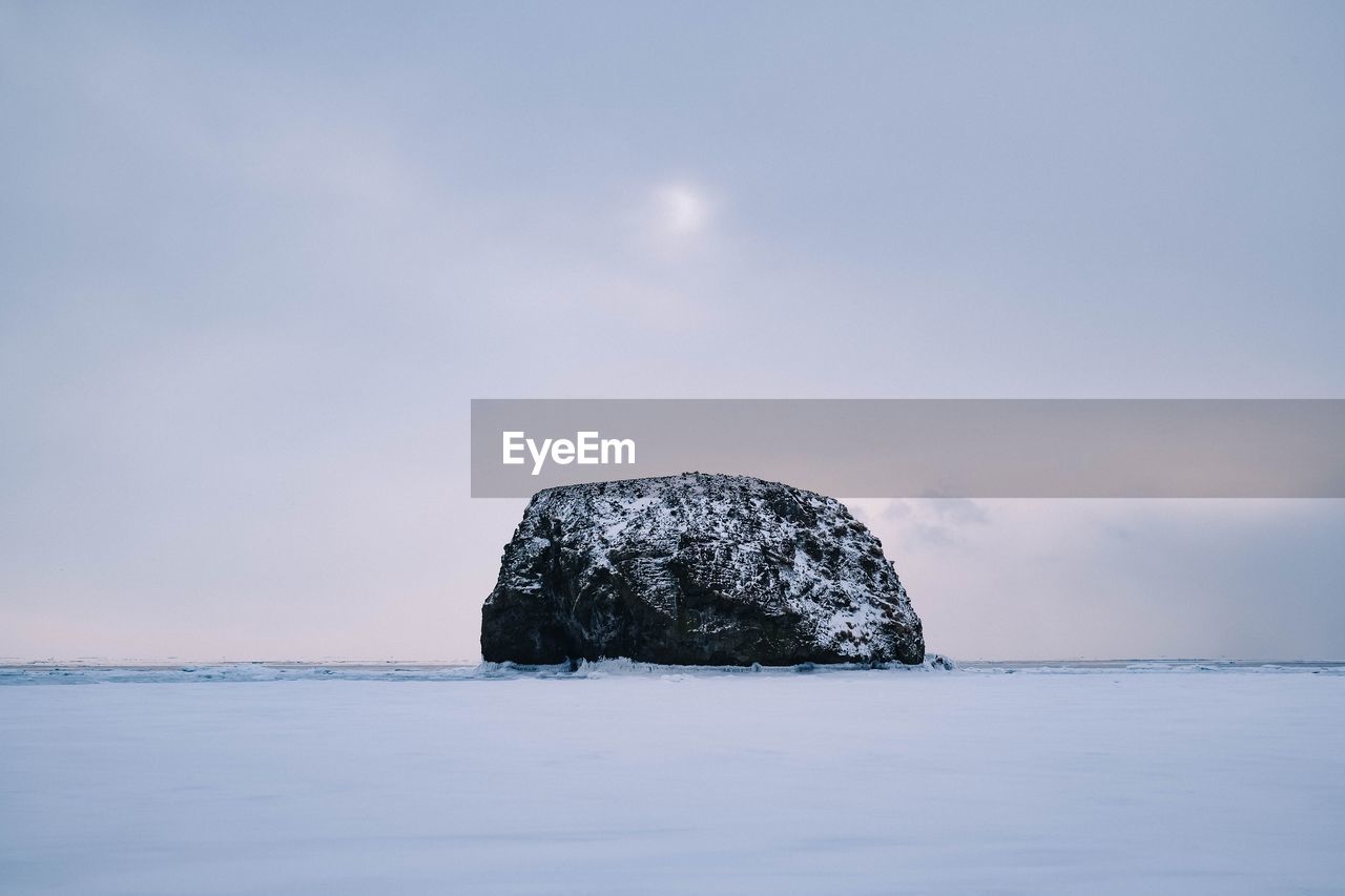 View of rock formation in sea against sky