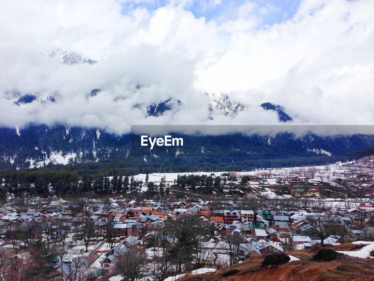 High angle view of houses on field against cloudy sky during winter