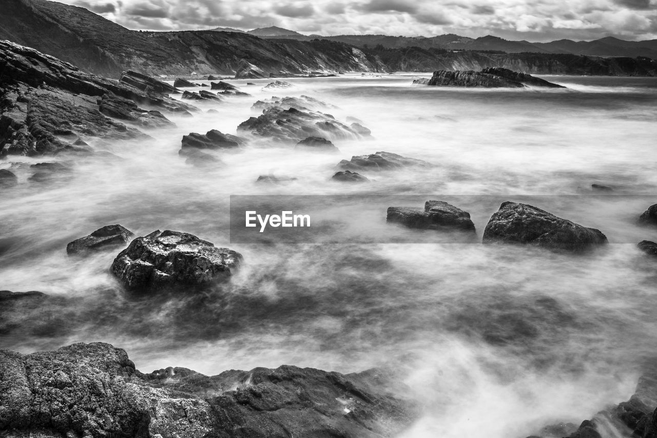 Scenic view of lake against cloudy sky