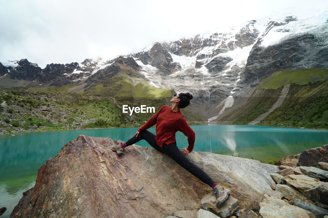 Woman standing on rock against mountain