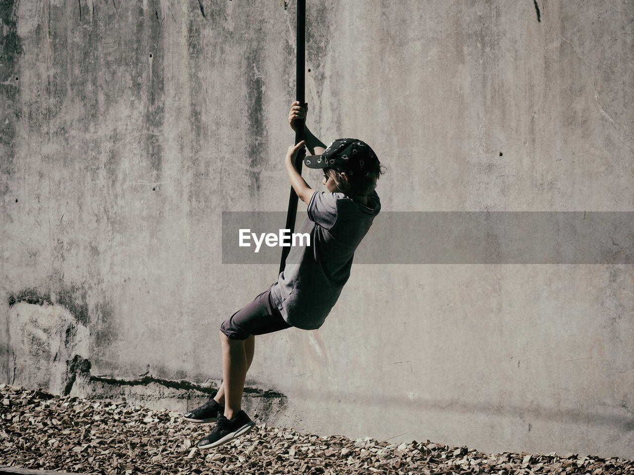 Playful boy hanging on rope